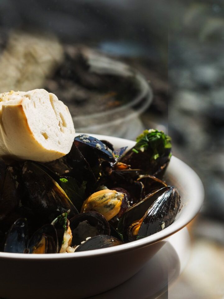 A bowl of mussels with bread